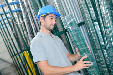 Man selecting shrink wrapped pack of poles