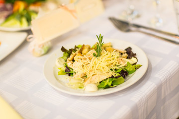 Caesar salad with chicken and greens on a table