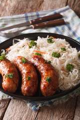 Traditional fried sausage and sauerkraut on a plate. vertical
