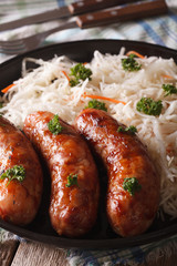 Hot sausage and sauerkraut on a plate close-up. vertical
