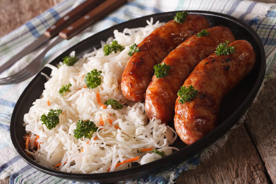 Traditional fried sausage and sauerkraut on a plate. Horizontal
