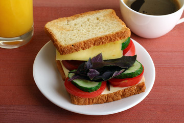 toast the main dish on a plate with tomatoes and cucumbers with cheese. Drinks on wooden table