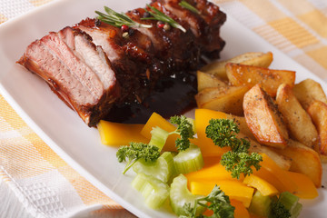 BBQ pork ribs with salad and fried potatoes close-up. horizontal
