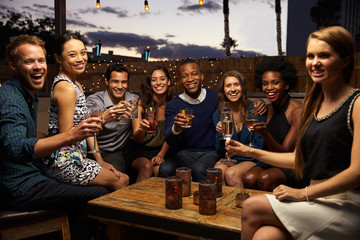 Portrait Of Friends Enjoying Night Out At Rooftop Bar