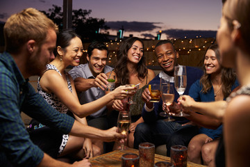 Group Of Friends Enjoying Night Out At Rooftop Bar - Powered by Adobe