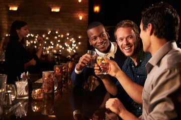 Male Friends Enjoying Night Out At Cocktail Bar