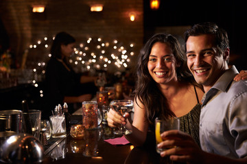 Portrait Of Couple Enjoying Night Out At Cocktail Bar