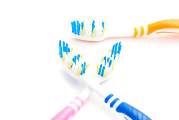 three colored toothbrushes