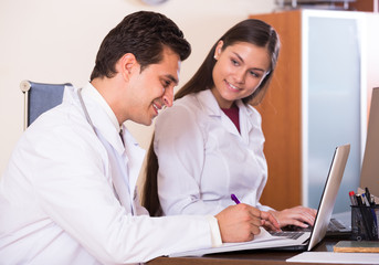 Fototapeta premium Family doctors with stethoscope working in office together