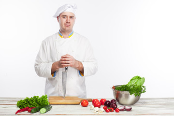 Chef posing with knife in his kitchen