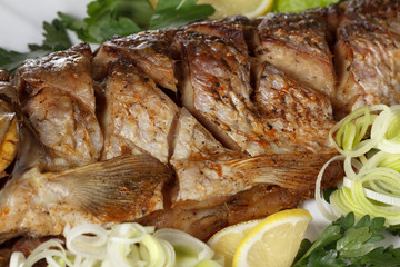 Roasted carp fish with vegetables entirely. Traditional Christmas menu.
