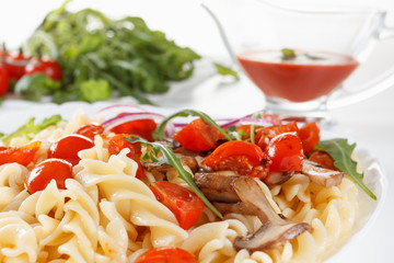 Pasta with mushrooms, cherry tomatoes and tomato sauce, italian food. Closeup