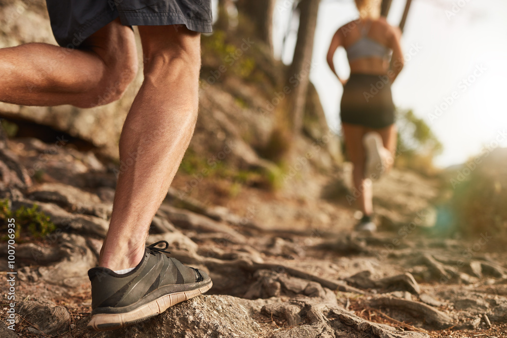 Wall mural Athletes run through rocky terrain