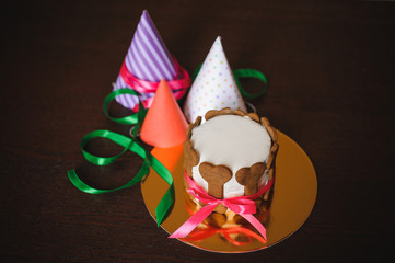 dog cake  decorated with bone cookies and birthday hat