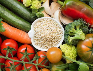 White sorghum grain in a bowl with vegetables