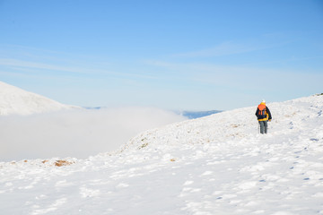 Naklejka na ściany i meble tourist climbs the snow-covered mountain