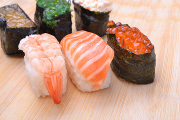 Salmon sushi in chopsticks on white background.