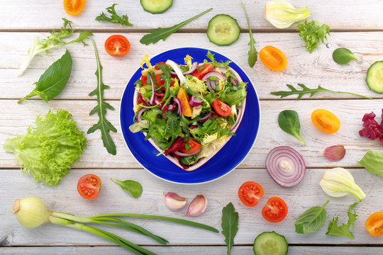 Fresh healthy salad in bowl on wooden background