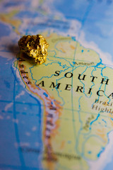 Close-up of a gold nugget on top of a map of Peru