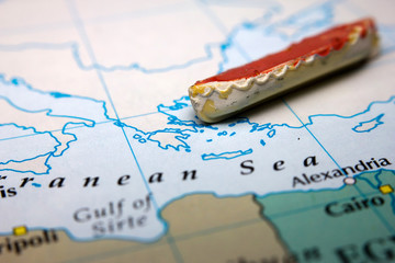 A boat and an antique map of Europe representing the immigration from the East
