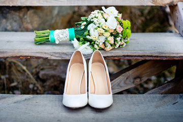 Woman's wedding shoes with the bouquet