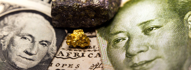 Close-up of a gold nugget / rare earth metal in between a 1 dollar note (showing George Washington)...
