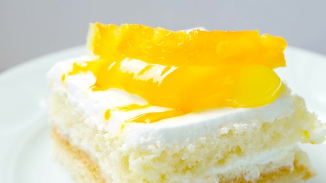 Slice of cake with pineapple. Closeup, rotates on white plate.
