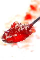 Strawberry jelly with oatmeal in the spoon. Isolated photo.