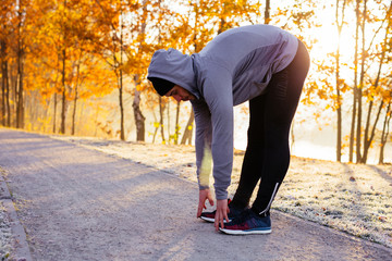 Young runner stretching before winter run