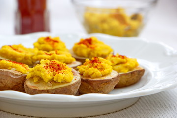 plate with baked potatoes and curry hummus