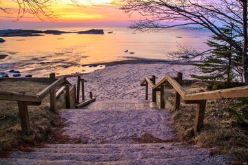 Fototapeta na wymiar Lake Superior Sunset. Stairs leading to a beautiful Lake Superior sunset beach at the Hurricane River Campground in Pictured Rocks National Lakeshore.