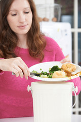 Woman Scraping Food Leftovers Into Garbage Bin