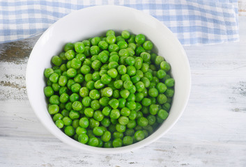 Green peas in a white bowl.