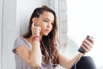 teenage girl with smartphone and earphones