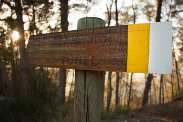 Señalización de senderos sobre un atardecer en la montaña.