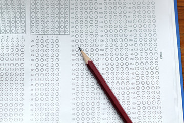 glasses and pencil on Standardized test form with answers bubble