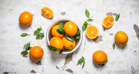 Orange style. Fresh oranges with leaves in a Cup .