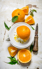 Squeezing juice from fresh oranges . On rustic background.