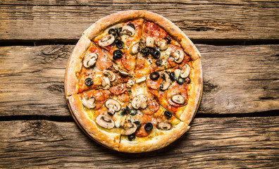 Italian pizza with olives and bacon .