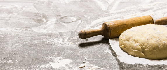  The dough on the paper with a rolling pin.