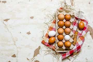 The cassette with eggs, hay and whisk on the fabric.