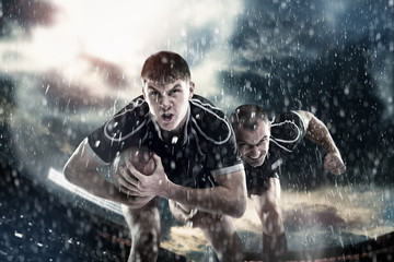 Rugby sportsmens, players run on a stadium - obrazy, fototapety, plakaty