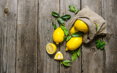 Fresh lemons into an old bag with leaves.