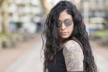 Urban portrait of beautiful woman with sunglasses heavy metal street.