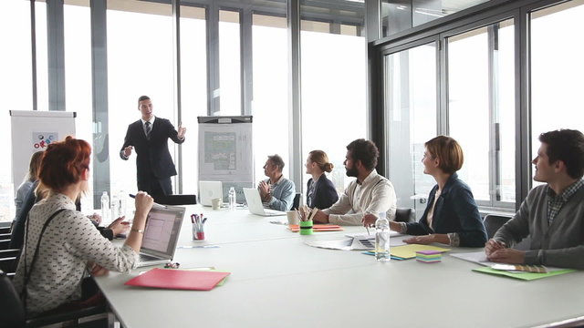 Colleagues applauding director during a meeting in conference room