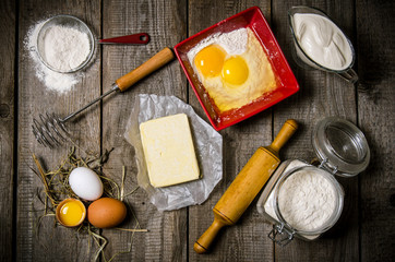 Preparation of the dough. Ingredients for the dough - egg, flour, butter, sour cream, and whisk with a rolling pin.