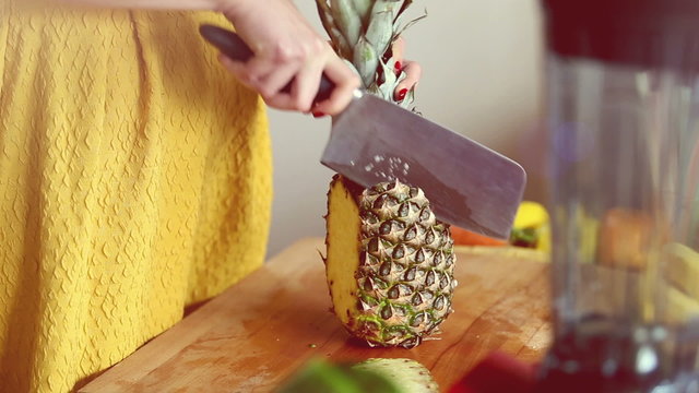 View of woman hands cutting pineapple