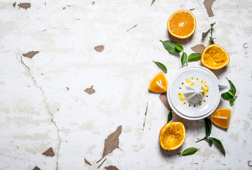 Juicer with fresh oranges. The fresh orange juice.