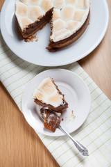 Sweet cake with chocolate on a light wooden table