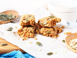 Oatmeal energy bars with oats, pumpkin seeds, peanut butter, agave syrup, sesame and sunflower seeds, closeup